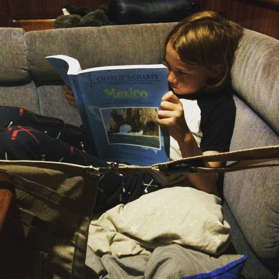 Carson doing some bedtime reading- 'Charlies Charts Guide to Cruising Mexico'. A true boat kid!